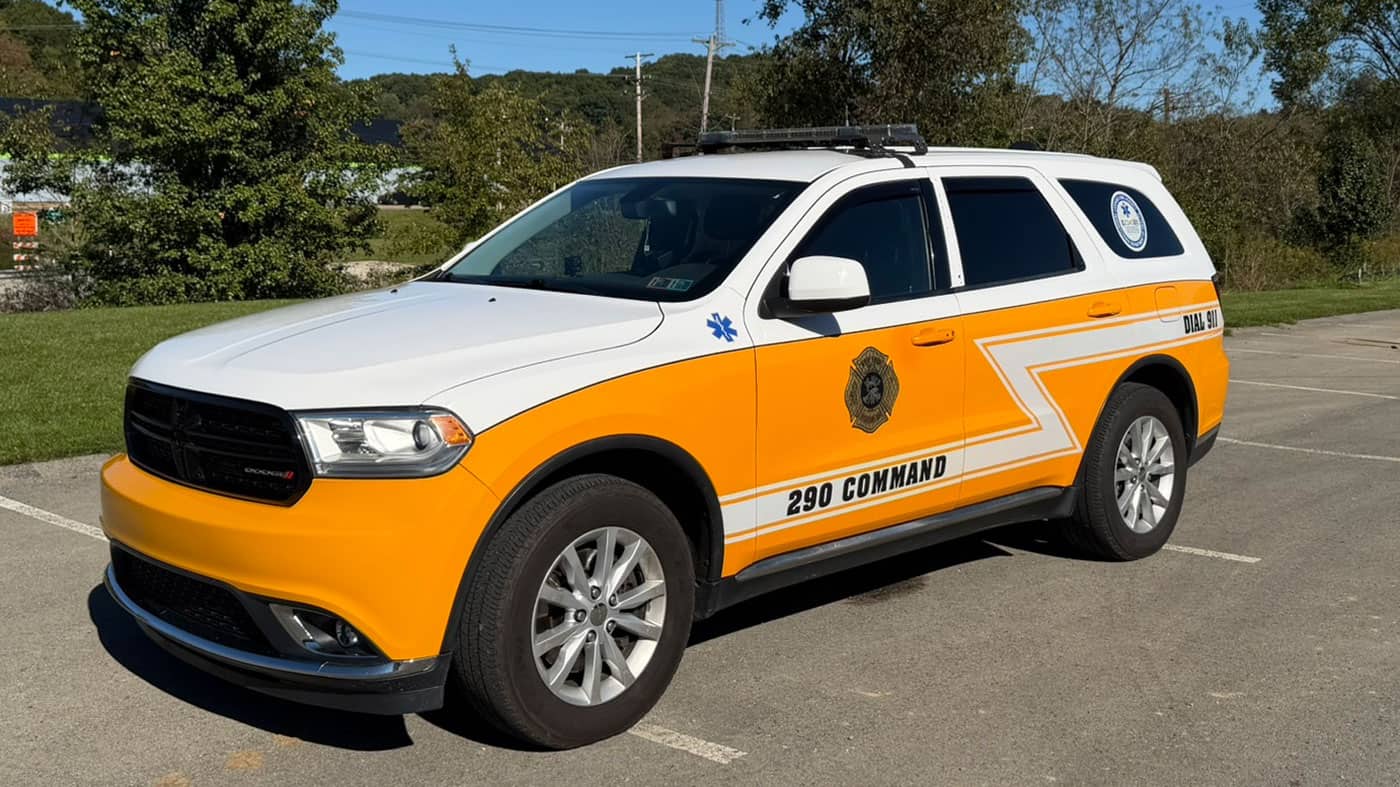 White and yellow Dodge emergency command SUV parked in a lot, labeled “290 COMMAND” on the side.